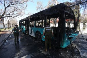 Un bus quemado tras incidentes y enfrentamientos en la comuna de Huechuraba