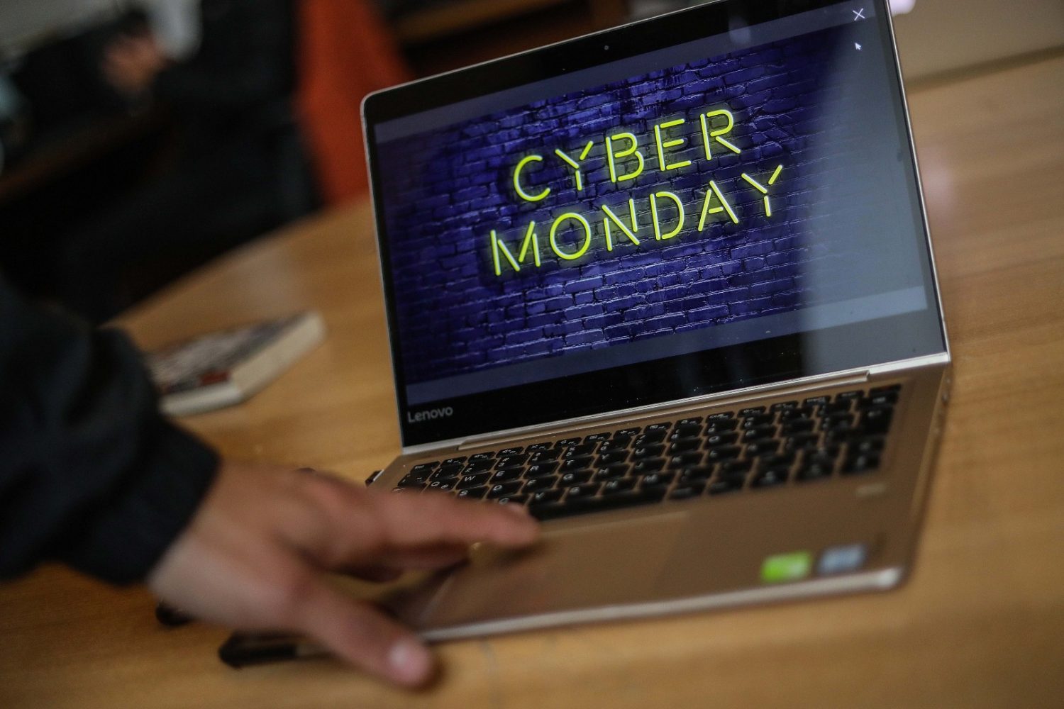 Mano de una persona sobre un notebook que dice Cyber Monday.