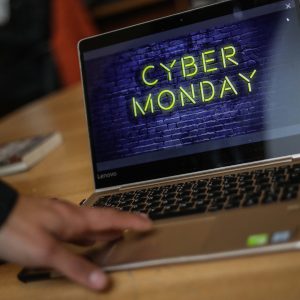 Mano de una persona sobre un notebook que dice Cyber Monday.